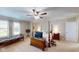 Spacious main bedroom features a four-poster bed, ceiling fan, and natural light at 14195 Holly Berry Cir, Fishers, IN 46038