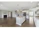 Spacious open-concept kitchen with stainless steel appliances, hardwood flooring and connected living room at 14878 Horse Branch Way, Fishers, IN 46040
