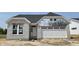 New construction home showing a gray brick exterior, white garage door, and dark grey roof at 14910 Garden Mist Pl, Fishers, IN 46037