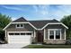 Charming single-story home with stone accents, a two-car garage, and a well-manicured lawn at 14910 Garden Mist Pl, Fishers, IN 46037