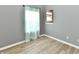 Bedroom with window to kitchen, wood-look flooring, and neutral walls at 1632 Blankenship Dr, Indianapolis, IN 46217