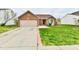 Charming one-story home featuring a brick facade, attached garage, and a lush front yard on a sunny day at 1632 Blankenship Dr, Indianapolis, IN 46217