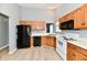 Kitchen with wood cabinets, white appliances, and wood-look floors at 1632 Blankenship Dr, Indianapolis, IN 46217