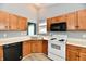 Kitchen with wood cabinets, white appliances, and wood-look floors at 1632 Blankenship Dr, Indianapolis, IN 46217