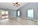 Bright living room featuring wood-look flooring, a ceiling fan, a sliding glass door to the deck and windows at 1632 Blankenship Dr, Indianapolis, IN 46217