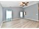 Bright living room with vaulted ceilings, wood-look floors, a ceiling fan, and blue accent curtains at 1632 Blankenship Dr, Indianapolis, IN 46217