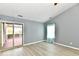 Bright living room with wood-look floors, sliding doors to the patio, and a large window with curtains at 1632 Blankenship Dr, Indianapolis, IN 46217