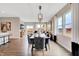 Open concept dining room with modern chandelier, views to living area, and hardwood floors at 16930 Sandhurst Pl, Westfield, IN 46074