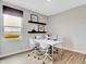 Well-lit home office with a modern desk, shelves, and a window providing natural light at 16930 Sandhurst Pl, Westfield, IN 46074