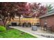 Outdoor brick patio with a dining table set, grill, landscaped lawn, and surrounded by a privacy fence at 171 W 44Th St, Indianapolis, IN 46208