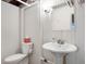 Simple basement bathroom with white paneling, a pedestal sink, and a standard toilet setup at 171 W 44Th St, Indianapolis, IN 46208