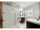 Bright bathroom featuring a glass enclosed shower, and dual vanities with dark wood cabinets at 171 W 44Th St, Indianapolis, IN 46208