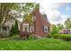 Charming brick house boasts a manicured lawn and vibrant landscaping with a cozy front entrance at 171 W 44Th St, Indianapolis, IN 46208