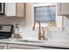 Modern kitchen sink with quartz countertops, white backsplash, and stainless steel appliances at 171 W 44Th St, Indianapolis, IN 46208