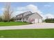 Gray two-story home with a long driveway, spacious lawn, and a three-car garage at 180 S 400 W, Lebanon, IN 46052