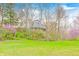 Scenic view of a unique home nestled among trees with vibrant flowering bushes, offering privacy and natural beauty at 1907 N Washington St, Danville, IN 46122