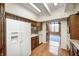 Kitchen with wood cabinets and trim and white refrigerator with views to sun room at 1907 N Washington St, Danville, IN 46122