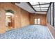 Sunroom opens into a kitchen with white appliances and natural wood cabinets, and a bright living room with wood panels at 1907 N Washington St, Danville, IN 46122