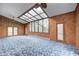 Bright living room features floor to ceiling glass and an attached sun room and natural wood paneling at 1907 N Washington St, Danville, IN 46122