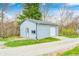 Well-maintained light gray shed with garage door and ADT security, situated on a gravel driveway and lawn at 1907 N Washington St, Danville, IN 46122