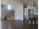 Open-concept living room with hardwood floors, stainless steel appliances and a staircase access at 210 E Monroe St, Alexandria, IN 46001