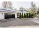 A well-maintained property featuring a detached garage, manicured landscaping, and a paved driveway at 222 E 71St St, Indianapolis, IN 46220