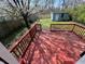 Red painted wood deck with views of the backyard, shed, and blossoming tree at 2250 N Capitol Ave, Indianapolis, IN 46208