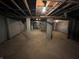 Unfinished basement with exposed wood beams, utilities, brick columns, and concrete floors at 2250 N Capitol Ave, Indianapolis, IN 46208