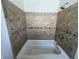 Close up of bathtub and shower area featuring travertine tile at 2250 N Capitol Ave, Indianapolis, IN 46208