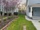 Charming side yard featuring a lush lawn, brick-edged garden, and flowering trees between two light blue houses at 2250 N Capitol Ave, Indianapolis, IN 46208