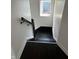 Dark wood stairs with a white wall and a window at the landing provide natural light at 2250 N Capitol Ave, Indianapolis, IN 46208