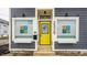 Close-up featuring a bright yellow door, signage, and planters, creating an inviting entrance to the building at 2329 Shelby St, Indianapolis, IN 46203