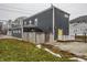 The dark gray home showcases a partial lawn, fence, and inviting yellow entry door at 2329 Shelby St, Indianapolis, IN 46203