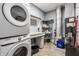 Functional laundry room equipped with a stacked washer and dryer, storage shelves, and utility sink at 2329 Shelby St, Indianapolis, IN 46203