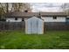 View of a backyard shed with a wooden fence and green grass, providing outdoor storage space at 248 Parkview Dr, Whiteland, IN 46184