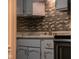 Updated kitchen featuring gray cabinets, a tiled backsplash, and modern fixtures at 248 Parkview Dr, Whiteland, IN 46184