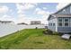 Large, grassy backyard enclosed by a white fence, featuring a seating area and lush landscaping for outdoor enjoyment at 2536 Maricopa Blvd, Whitestown, IN 46075