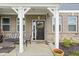 Inviting front porch features a seating area with cozy furniture and charming decorative touches and front door with wreath at 2536 Maricopa Blvd, Whitestown, IN 46075