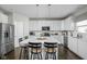 Bright kitchen features stainless steel appliances, white cabinets, and a large center island with barstool seating at 2536 Maricopa Blvd, Whitestown, IN 46075