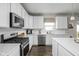 Modern kitchen with white cabinetry, stainless steel appliances, quartz countertops, and hardwood floors at 2536 Maricopa Blvd, Whitestown, IN 46075