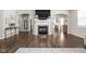 Elegant living room with hardwood floors, a fireplace, and an open layout leading to the kitchen at 2536 Maricopa Blvd, Whitestown, IN 46075