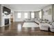 Open-concept living room with a fireplace, large windows, hardwood floors, and comfortable seating arrangement at 2536 Maricopa Blvd, Whitestown, IN 46075