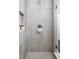 Shower stall clad in gray tile, featuring built-in storage and updated fixtures at 2536 Maricopa Blvd, Whitestown, IN 46075