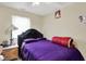 Bedroom features a plush, purple-covered bed and a side table with a lamp, creating a comfortable haven at 3110 S Temple Ave, Indianapolis, IN 46237