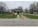 Cozy home with a stone facade, white porch, and gravel driveway; ideal for a starter home at 3302 S Rybolt Ave, Indianapolis, IN 46221