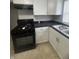 Kitchen featuring white cabinets, black countertops, and modern black appliances at 3302 S Rybolt Ave, Indianapolis, IN 46221