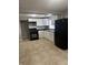Kitchen featuring white cabinets, black countertops, and modern black appliances at 3302 S Rybolt Ave, Indianapolis, IN 46221