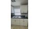 Kitchen features double stainless sink, white cabinetry, and black countertop at 3302 S Rybolt Ave, Indianapolis, IN 46221