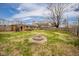 Spacious backyard with a stone fire pit, mature trees, and a wooden fence at 3502 River Park Dr, Anderson, IN 46012