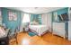 Bedroom features hardwood floors, bright blue walls, large bed, and cozy decor at 3502 River Park Dr, Anderson, IN 46012